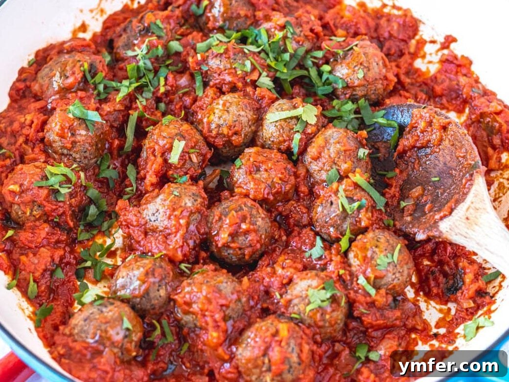 Feast on Plants: 35 Vibrant Recipes 39 Tofu meatballs simmering in a blue skillet with fresh parsley garnish.