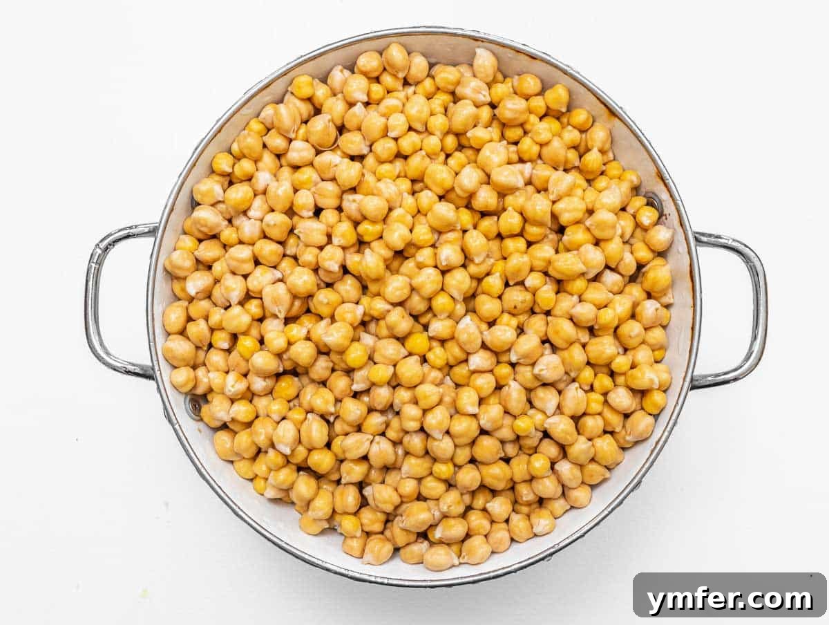 35 Plant-Powered Chickpea Creations 4 Dried chickpeas in a metal sieve after soaking and rinsing, ready for boiling.
