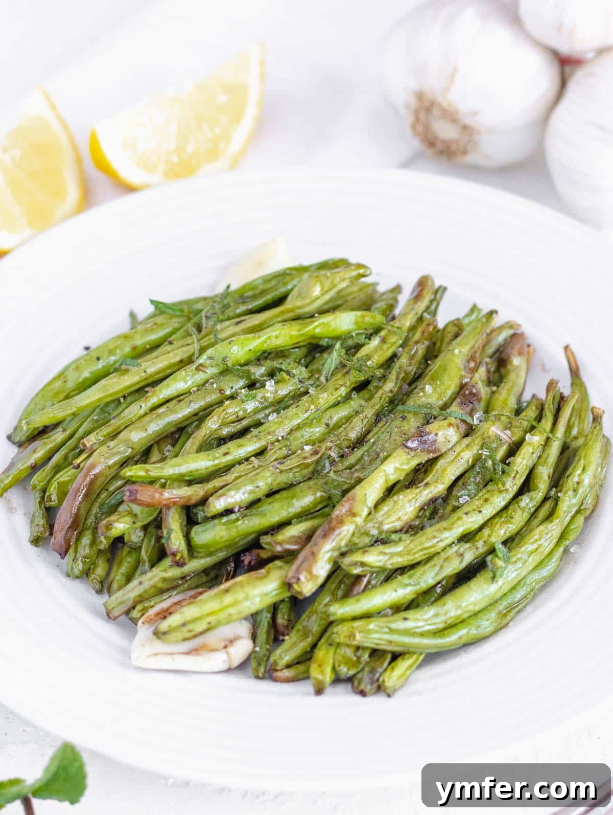 Crispy Air Fryer Green Beans 2 Crispy air fryer green beans on a plate, garnished with fresh herbs