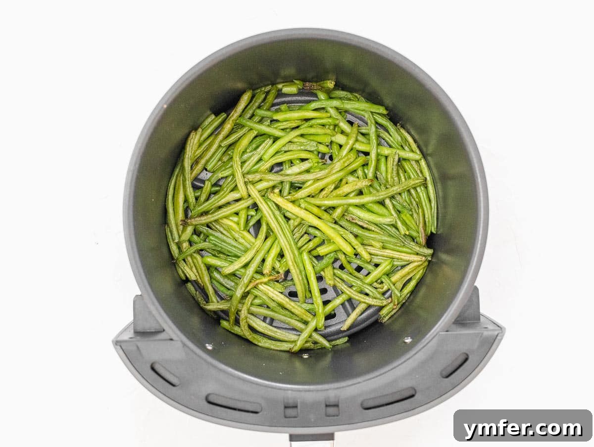 Crispy Air Fryer Green Beans 12 Frozen air fryer green beans cooking in the air fryer basket