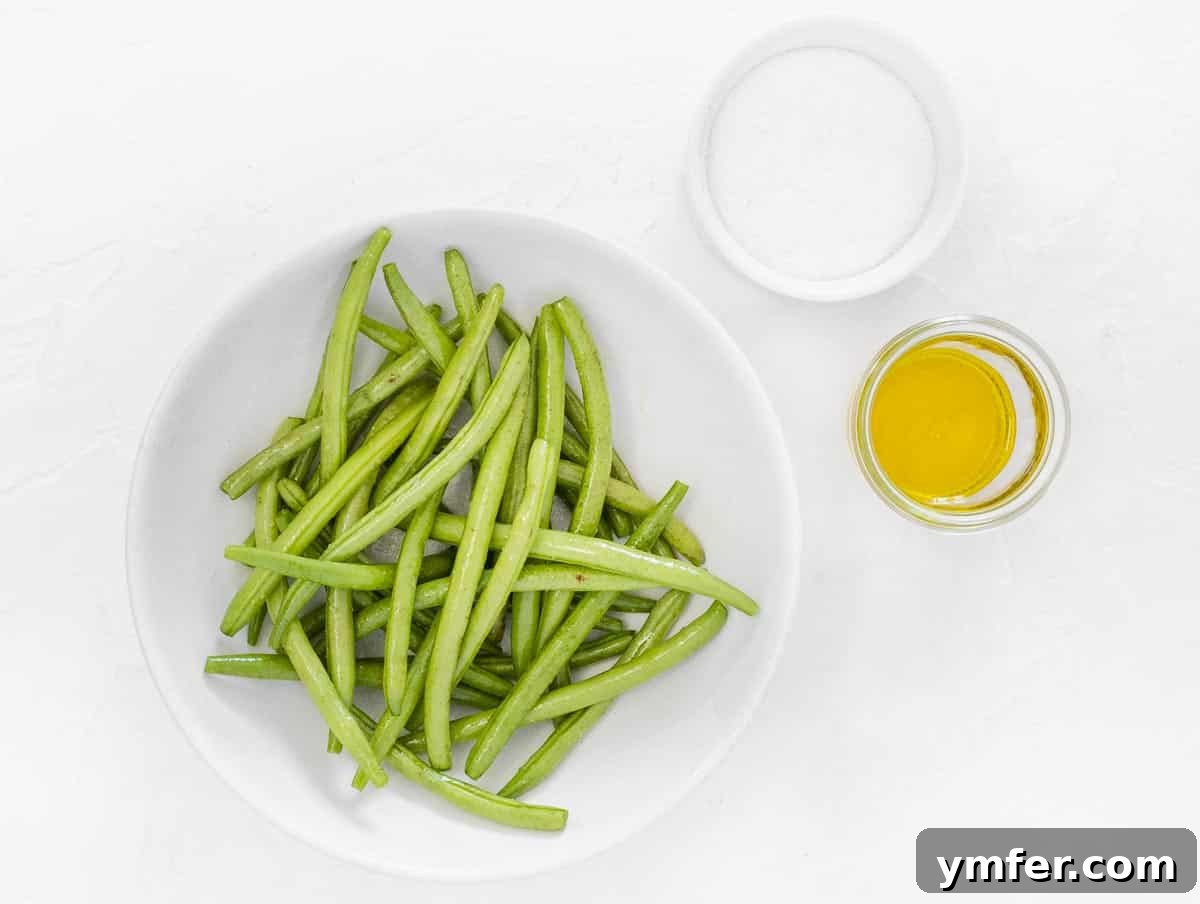 Crispy Air Fryer Green Beans 8 Green beans being tossed with olive oil and salt in a bowl