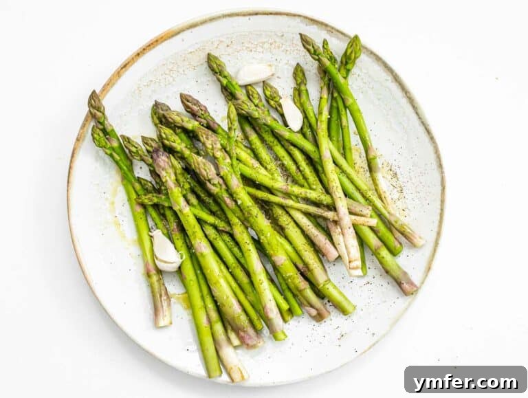 Crispy Air Fryer Asparagus 19 tossing asparagus in oil, salt, and pepper