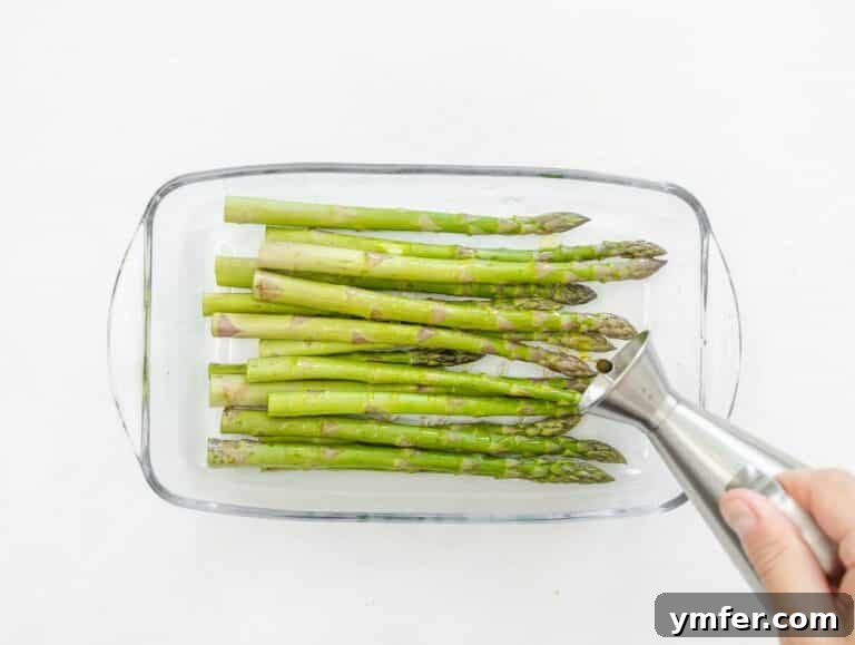 seasoning asparagus spears with olive oil, salt and pepper