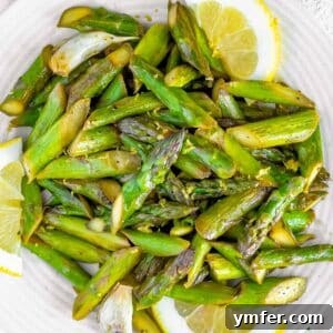 Sautéed asparagus with lemon on a plate, ready to be served.