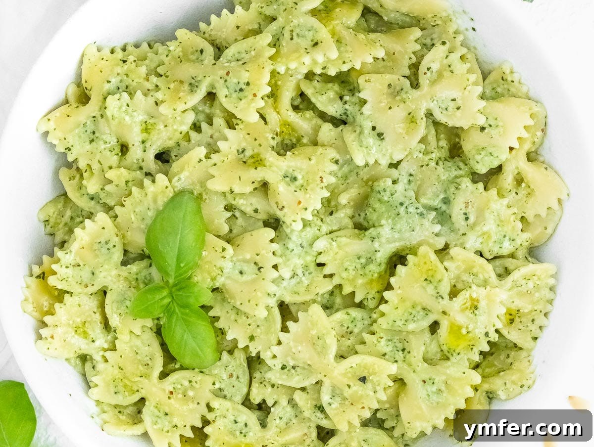 Silently, I'll translate "Zucchini Pesto" to English, verify it's already English, and then provide it as the final, unique title without any extra text or formatting, ensuring no special characters like asterisks or introductory phrases are included. 12 Vegan zucchini pesto mixed with spaghetti in a stylish serving bowl, garnished with fresh herbs