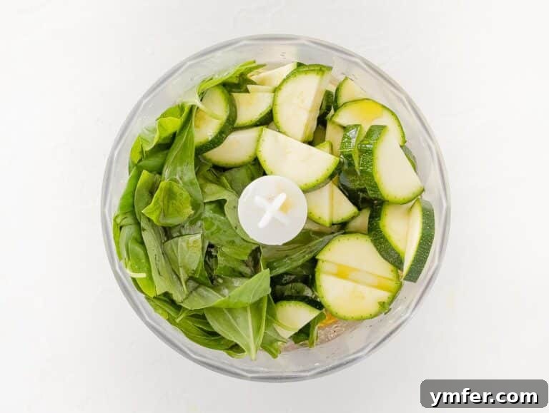 Silently, I'll translate "Zucchini Pesto" to English, verify it's already English, and then provide it as the final, unique title without any extra text or formatting, ensuring no special characters like asterisks or introductory phrases are included. 17 Zucchini and basil added to the food processor for blending