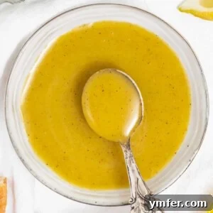 Honey mustard dressing in a bowl with a spoon