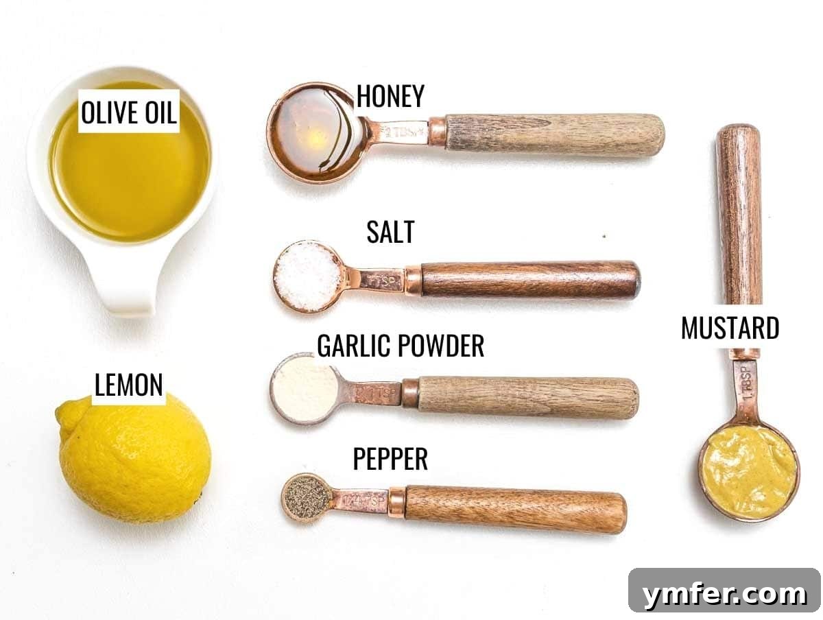 Golden Honey Mustard Bliss 4 Individual ingredients for honey mustard dressing laid out: olive oil, lemon, mustard, honey, garlic powder, salt, pepper
