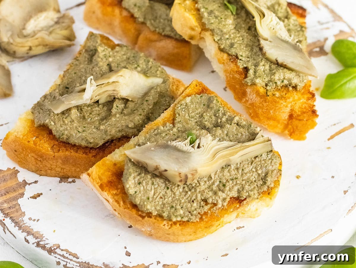 Savory Artichoke Spread 11 Crispy bruschetta topped with homemade artichoke pesto and a whole artichoke heart, ready to be served
