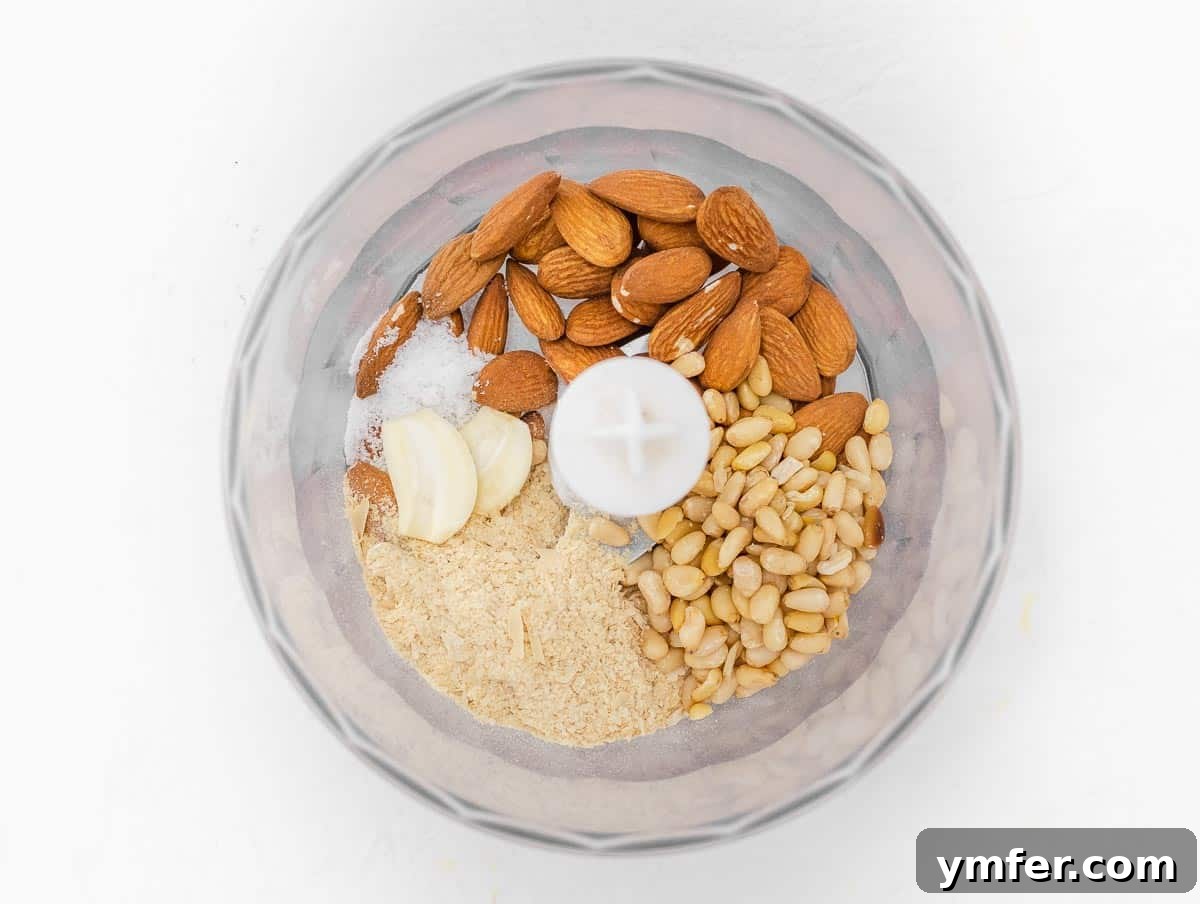 Savory Artichoke Spread 6 Dry ingredients including almonds, pine nuts, nutritional yeast, garlic, and salt added to a food processor bowl
