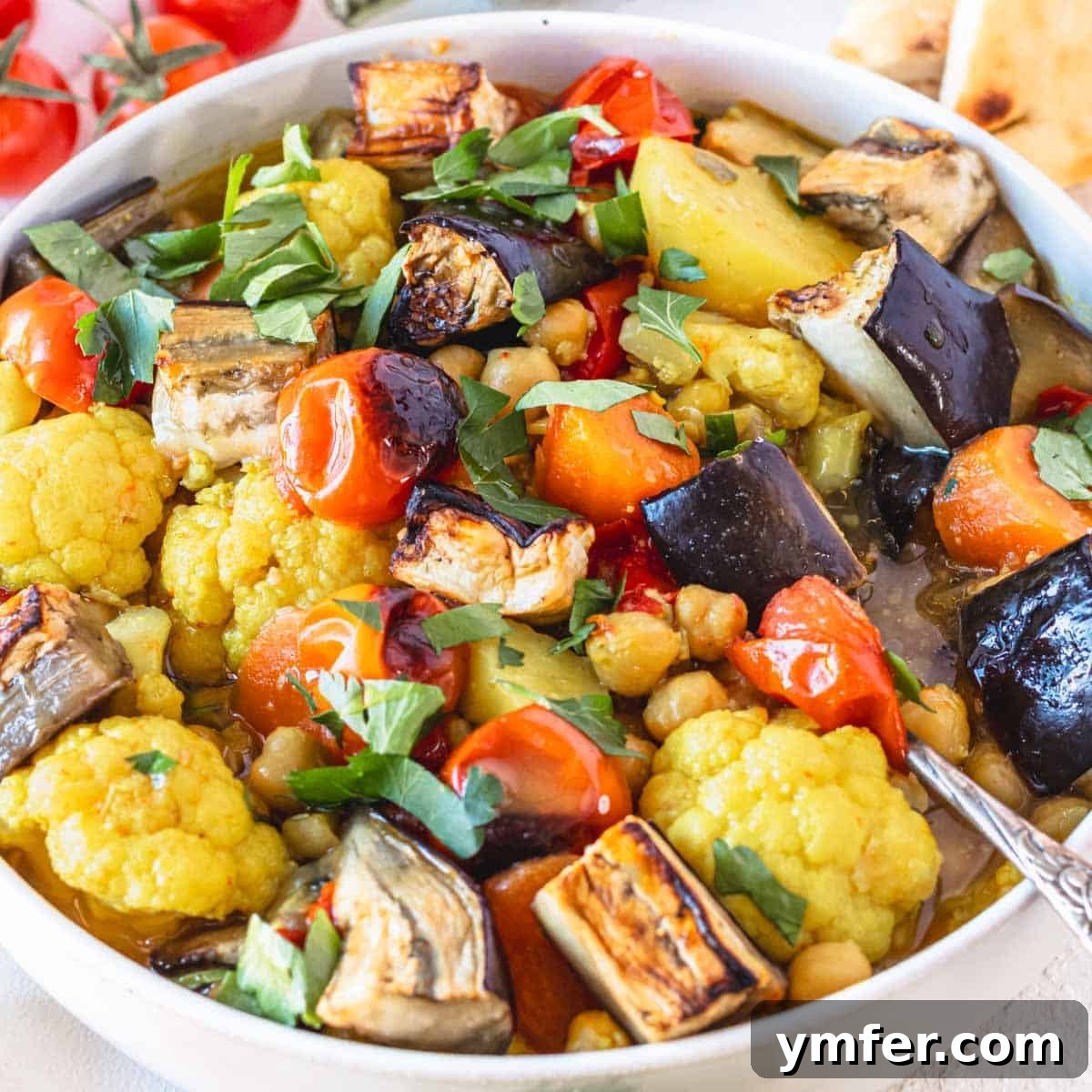 Eggplant Elevated 30 Exciting Recipes 16 Vegetable stew served in a white bowl with a silver spoon.