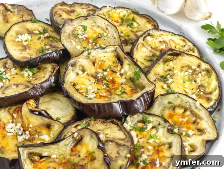 Eggplant Elevated 30 Exciting Recipes 28 Roasted eggplant slices being drizzled with a flavorful garlic seasoning.