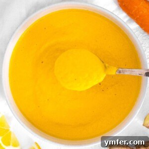 A bowl of fresh carrot ginger dressing garnished with sesame seeds.