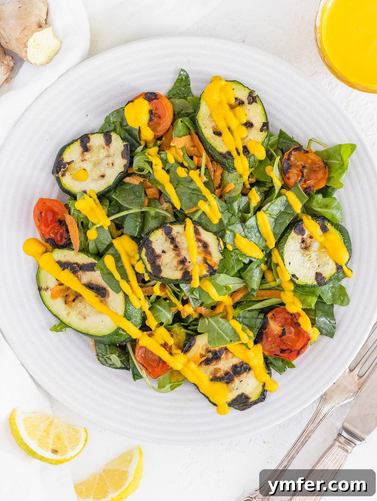 Vibrant Carrot Ginger Dressing 3 Grilled zucchini salad topped with vibrant carrot ginger dressing and fresh herbs.