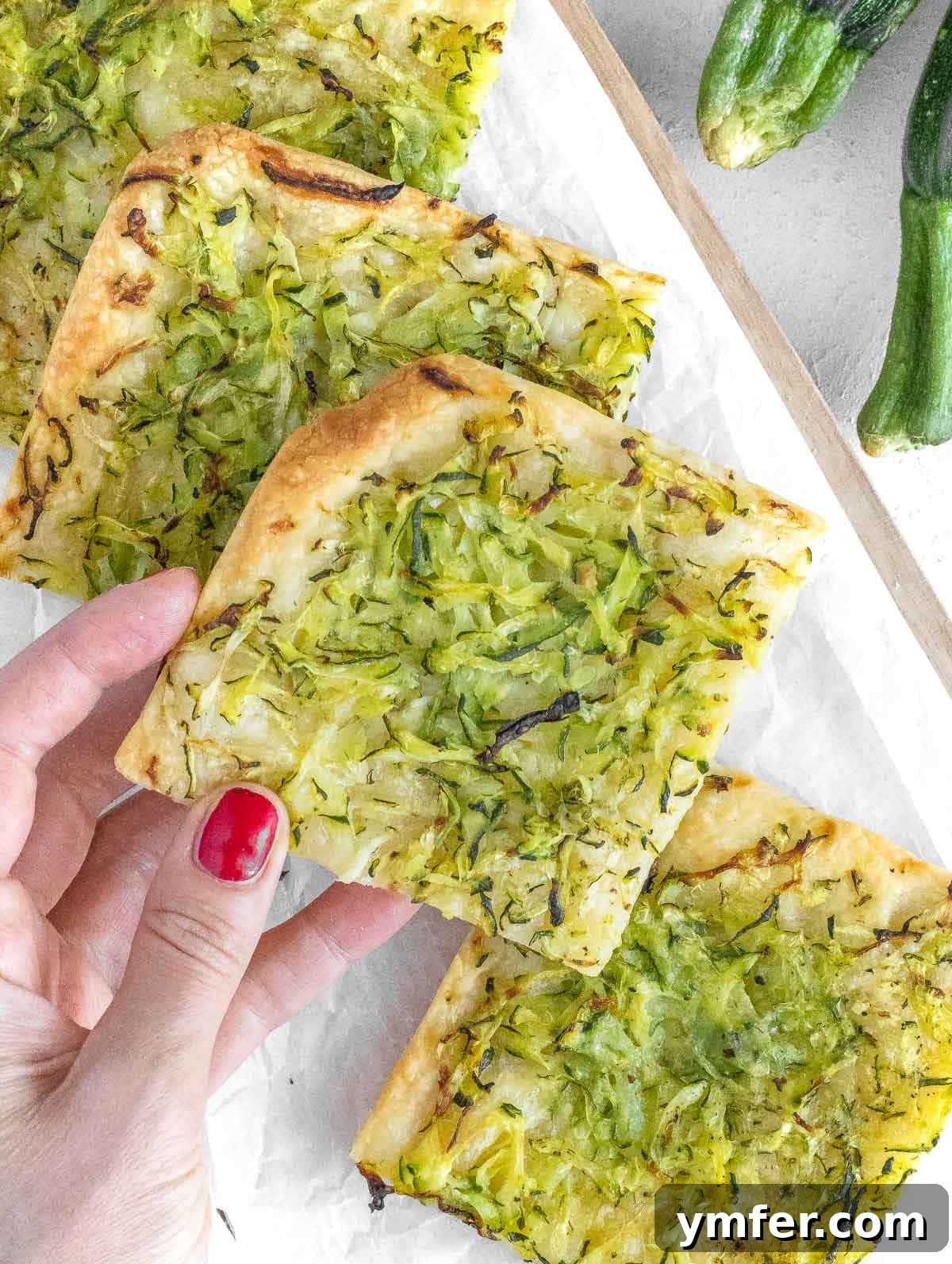 Rustic Zucchini Focaccia 2 Delicious golden-brown zucchini focaccia slices on a cutting board, ready to be served.
