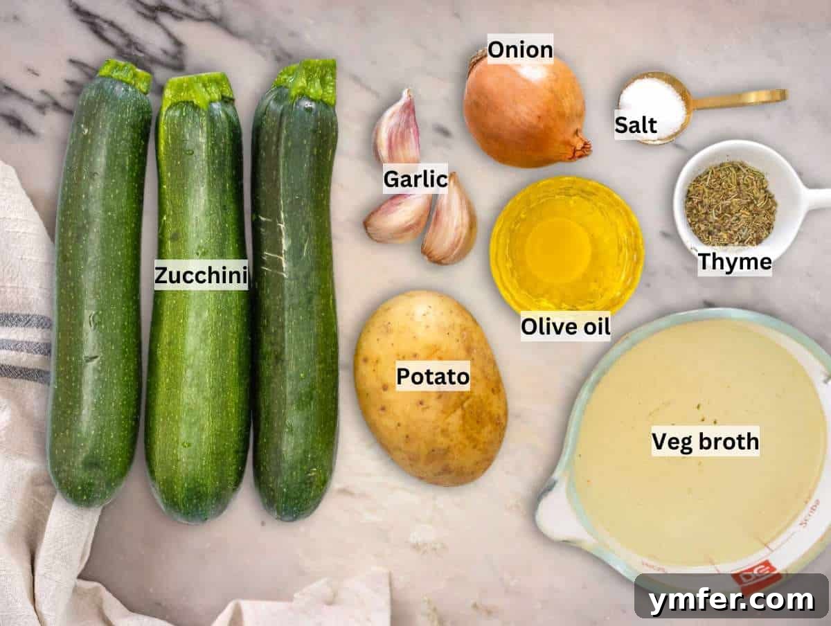Creamy Zucchini Bliss 3 Fresh ingredients laid out for making zucchini soup, including zucchini, potato, onion, and garlic.