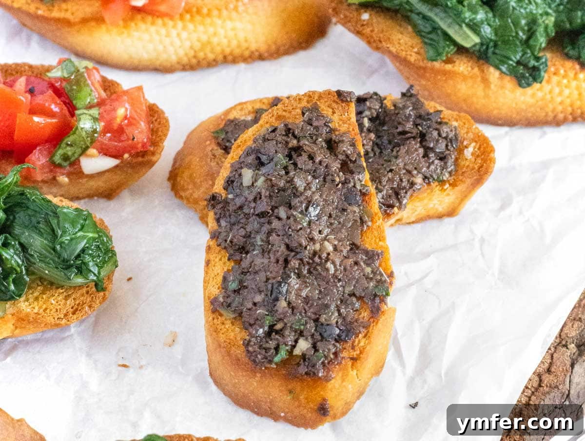 Rich Olive Spread 3 Olive tapenade generously spread on crostini, garnished with fresh herbs