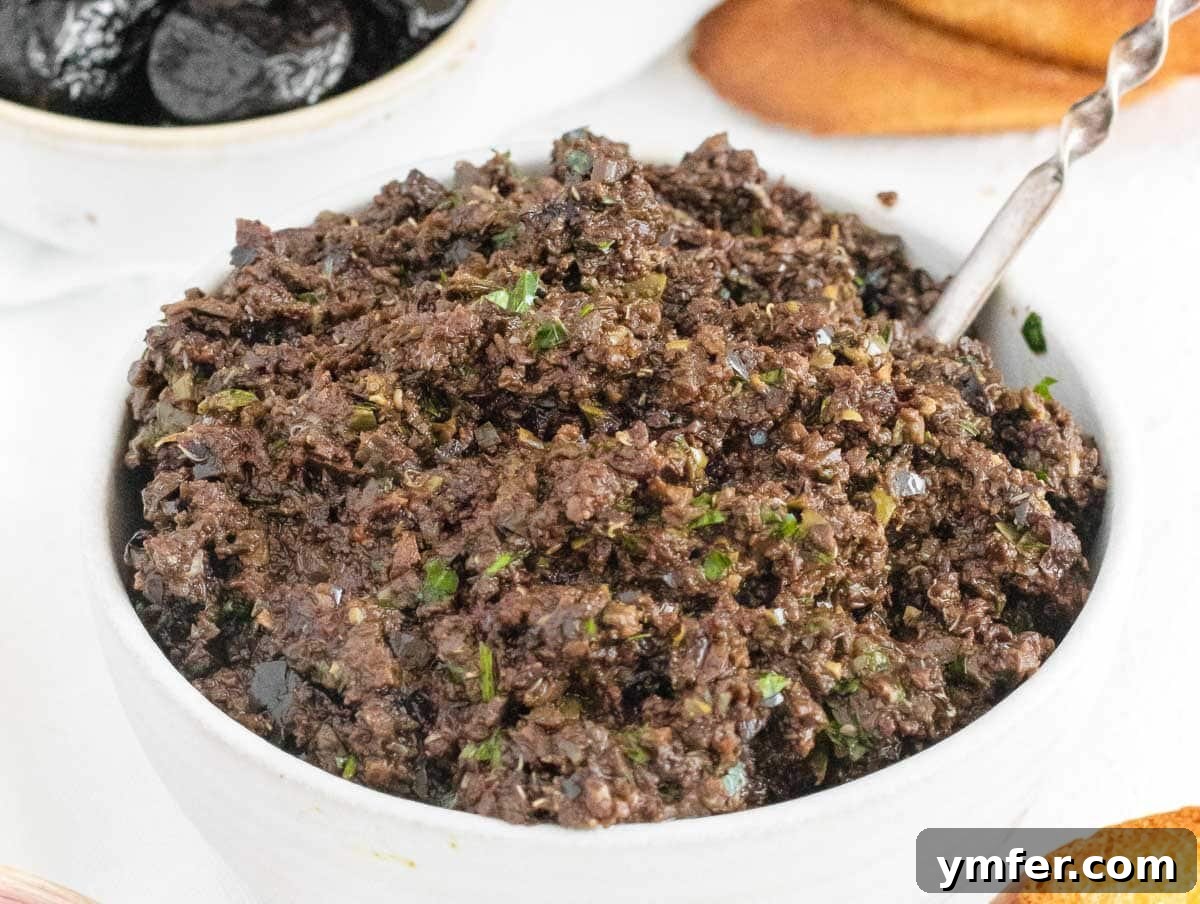 Rich Olive Spread 5 Close-up of olive tapenade in a rustic bowl with a spoon