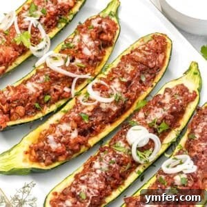 Zucchini boats with lentil filling, garnished with fresh herbs, presented as a delicious meal.