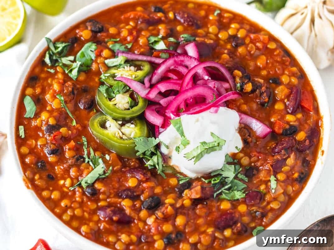 Velvety Vegan Sour Cream 4 Hearty lentil chili garnished with a dollop of creamy vegan sour cream and pickled jalapenos in a rustic bowl.