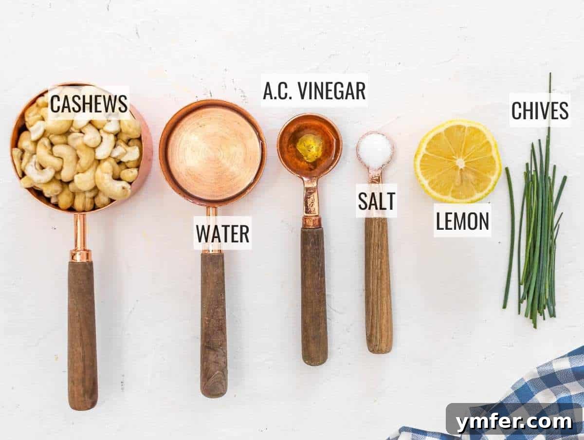 Velvety Vegan Sour Cream 6 Ingredients for vegan sour cream laid out on a wooden surface, including cashews, water, lemon, and apple cider vinegar.