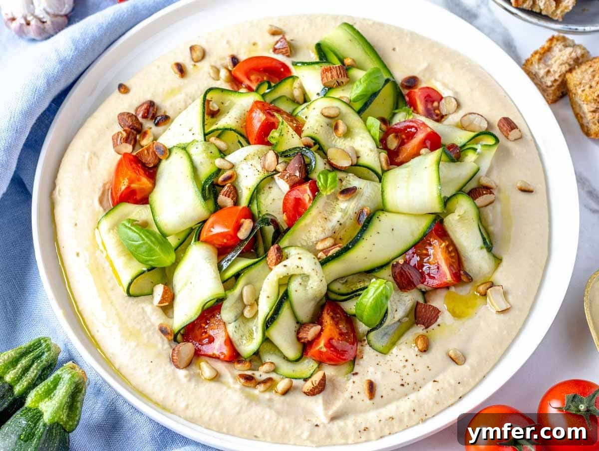35 Vibrant Vegetarian Lunch Ideas 11 A vibrant zucchini salad elegantly served on a creamy bed of hummus.