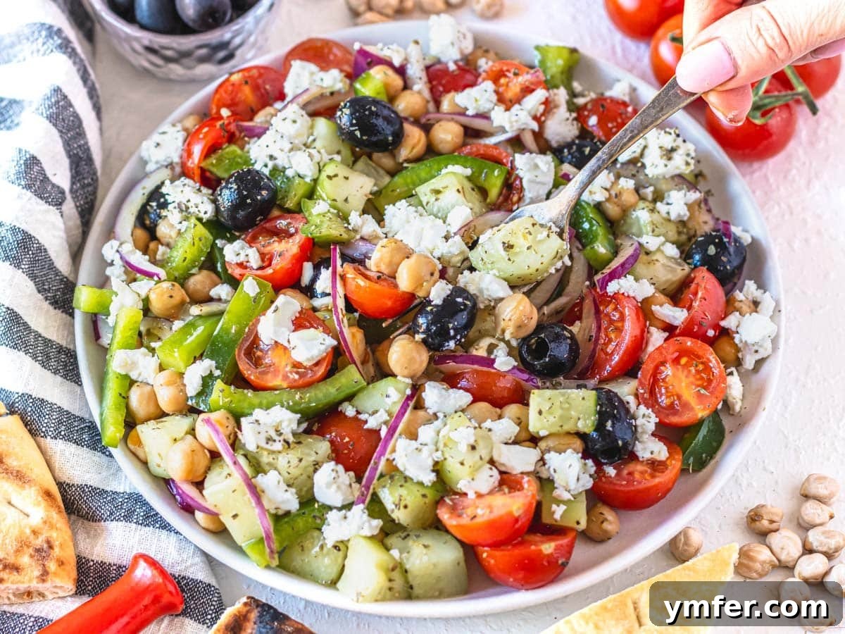35 Vibrant Vegetarian Lunch Ideas 17 A refreshing Greek chickpea salad with crumbled feta cheese on a white plate.