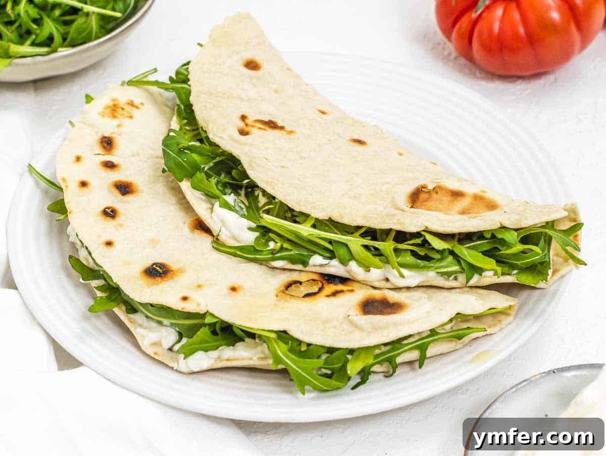 35 Vibrant Vegetarian Lunch Ideas 18 A warm piadina with melted cheese and fresh arugula, folded and ready to eat.
