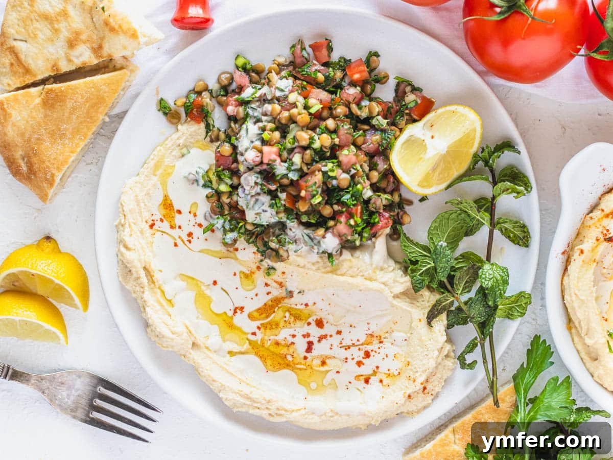 35 Vibrant Vegetarian Lunch Ideas 22 A vibrant lentil tabbouleh served with creamy hummus and a drizzle of tahini sauce.
