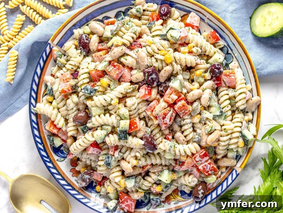 35 Vibrant Vegetarian Lunch Ideas 24 A delicious creamy pasta salad served on a blue plate with cucumber slices.