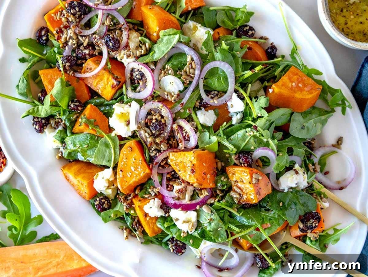 35 Vibrant Vegetarian Lunch Ideas 4 A vibrant sweet potato salad layered on a bed of leafy greens, topped with avocado slices.