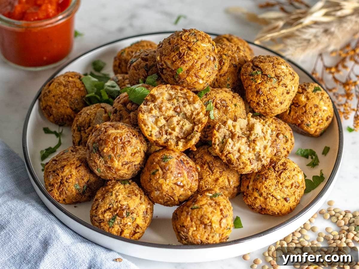 35 Vibrant Vegetarian Lunch Ideas 7 Savory lentil meatballs served as an appetizer on a white plate with a side of marinara sauce.