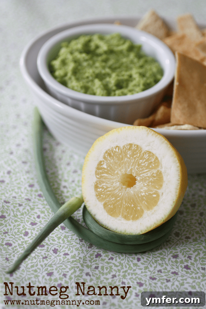 Edamame & Garlic Scape Hummus A garlic scape and lemon on a table.