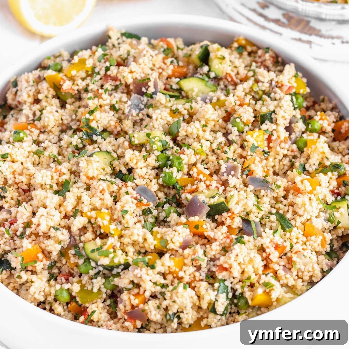 Couscous with vegetables in a bowl with hummus.