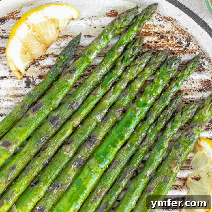 Grilled asparagus spears with lemon wedges.