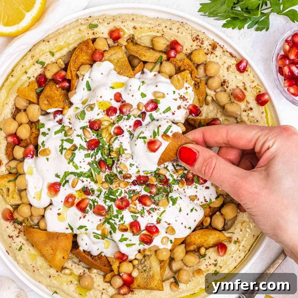 Fatteh dish with hummus, pita, and yogurt sauce.