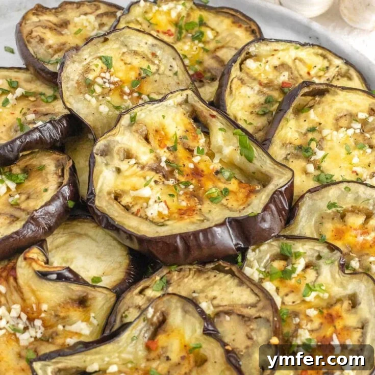 Roasted eggplant slices next to a bowl of hummus.