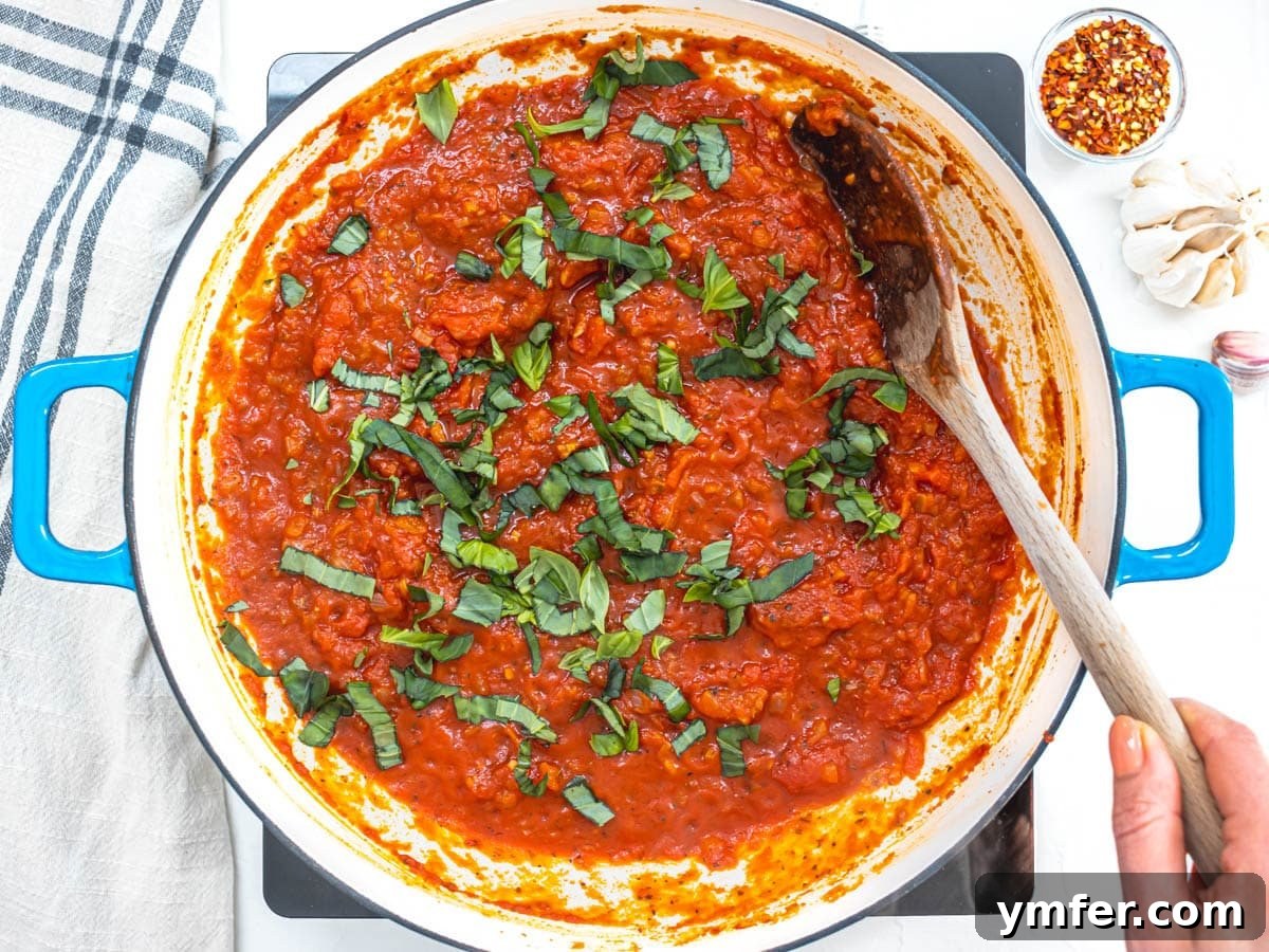 Rustic Marinara 11 fresh basil added to a marinara sauce in a skillet