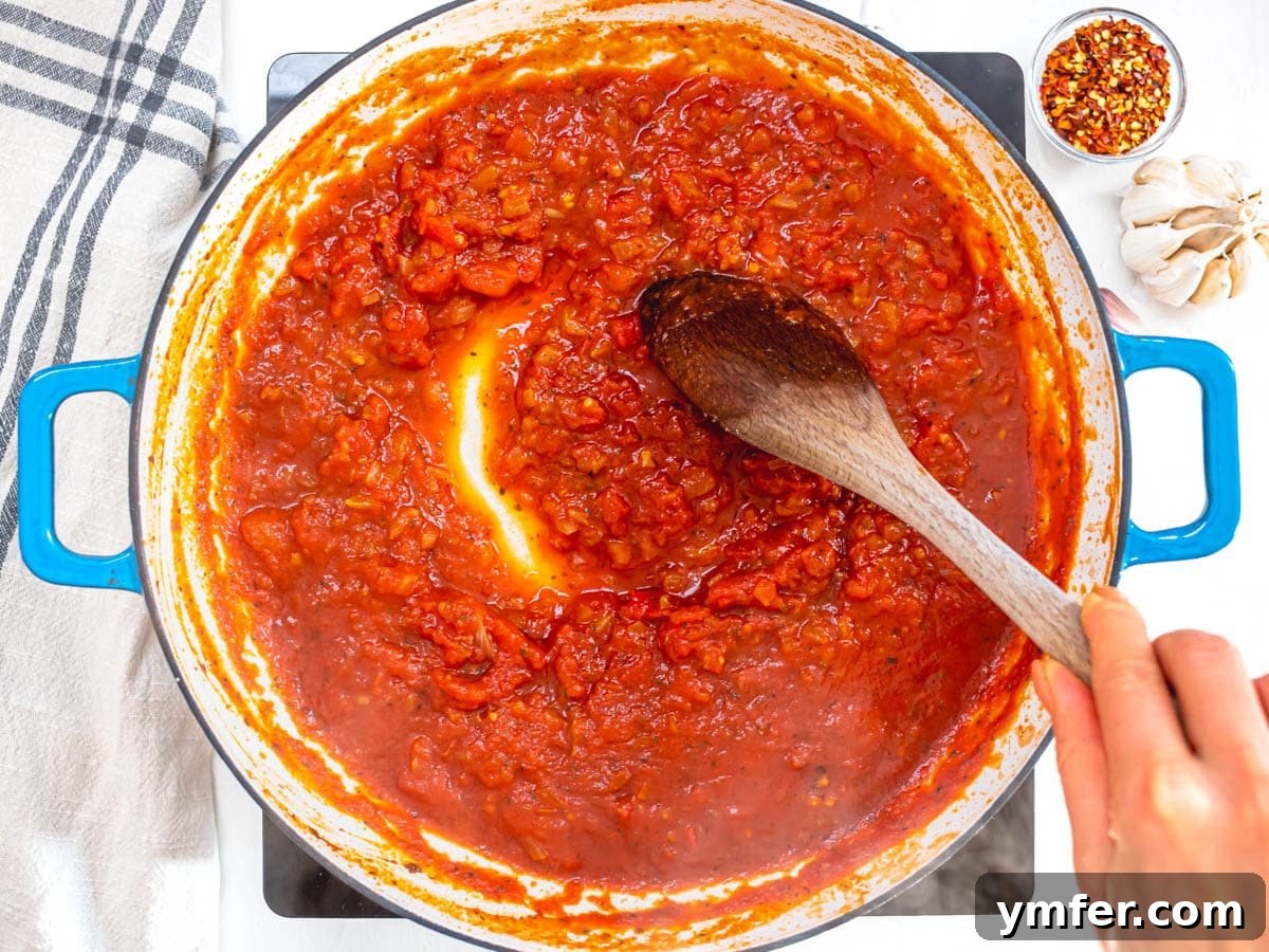 Rustic Marinara 10 whole peeled tomatoes in a blue skillet and a wooden spoon