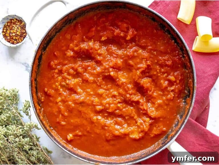 Step 2 Onion garlic and tomatoes simmering in pan for pasta alla Norma sauce.