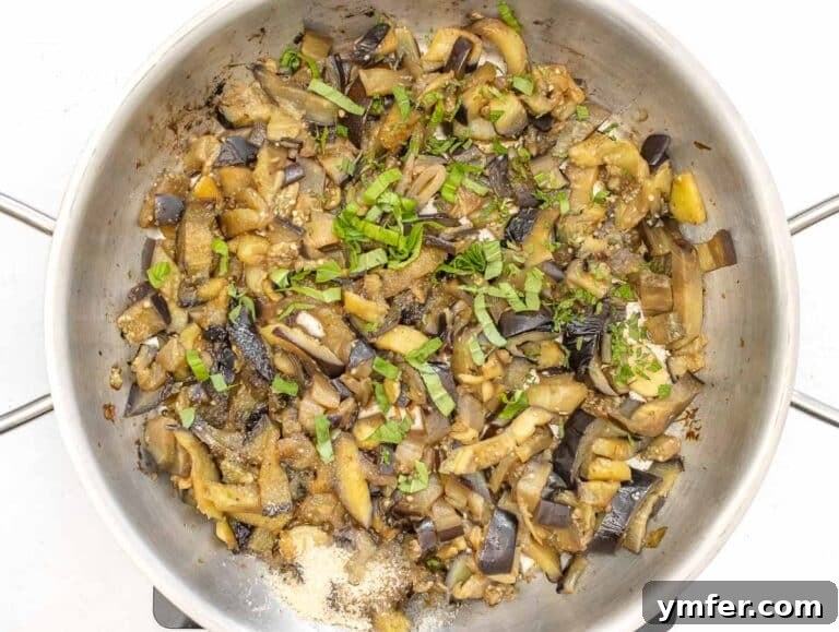 Sweet and Tangy Glazed Eggplant 14 Adding fresh herbs like basil and mint to the eggplant in the pan.