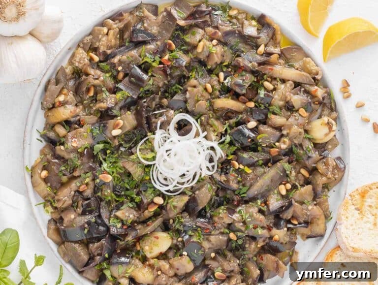 Sweet and Tangy Glazed Eggplant 15 Sweet and sour eggplant presented on a serving plate, garnished with fresh herbs and pine nuts.