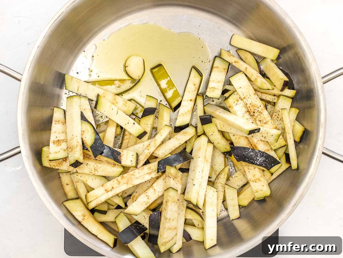 Sweet and Tangy Glazed Eggplant 7 Eggplant sticks sautéing in a hot skillet with olive oil and garlic.