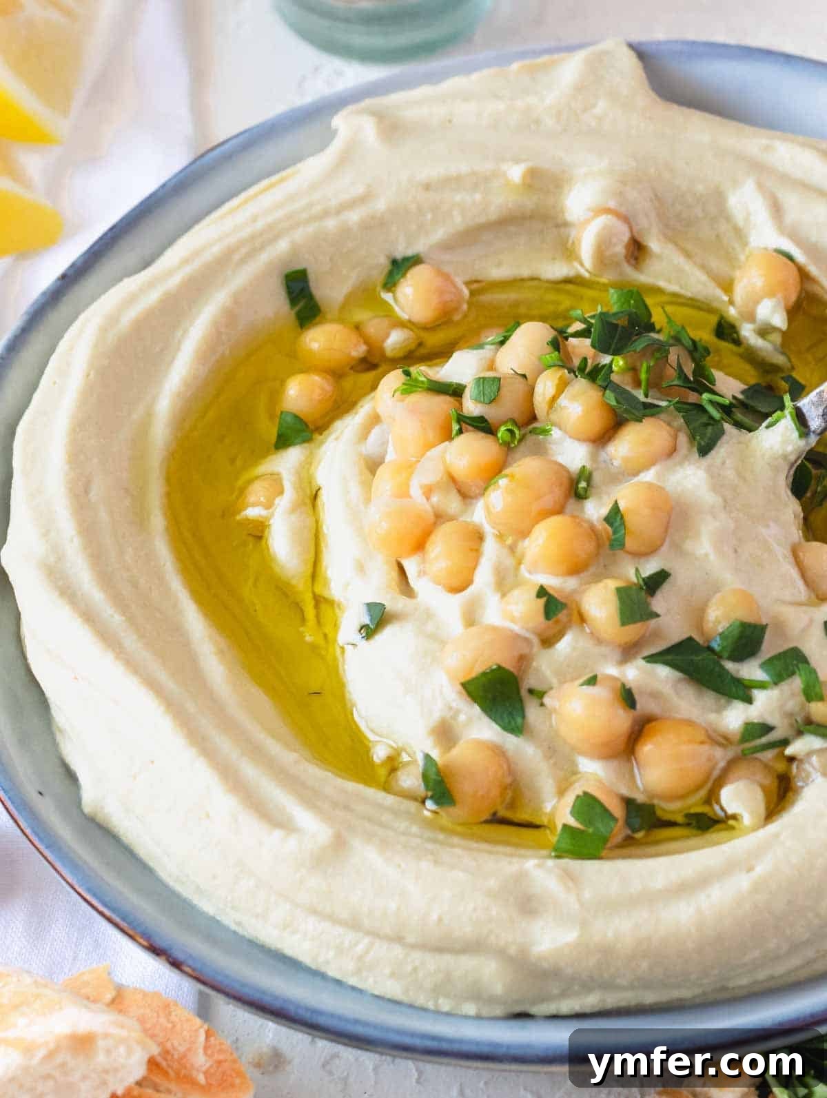 The Art of Hummus 5 A bowl of exceptionally smooth hummus, beautifully topped with whole chickpeas and a generous drizzle of olive oil, ready for dipping.