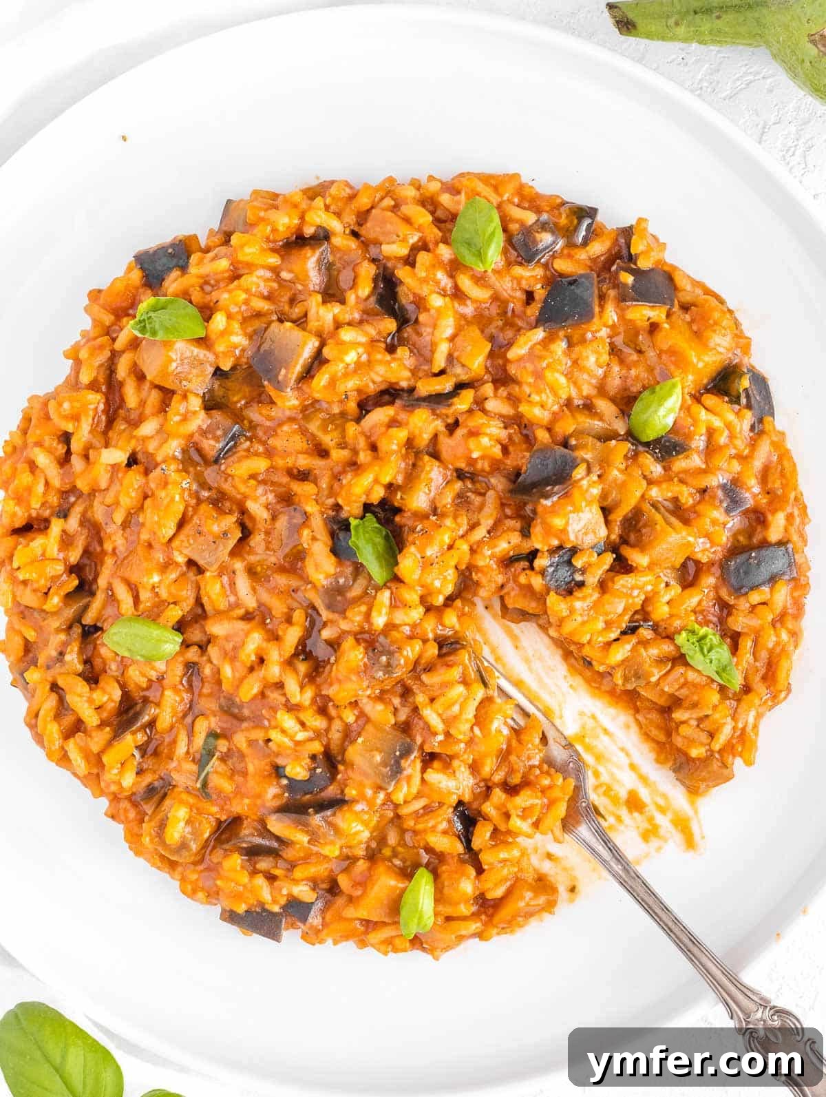 Velvet Aubergine Risotto 2 Delicious creamy eggplant risotto served in a bowl, garnished with fresh basil.