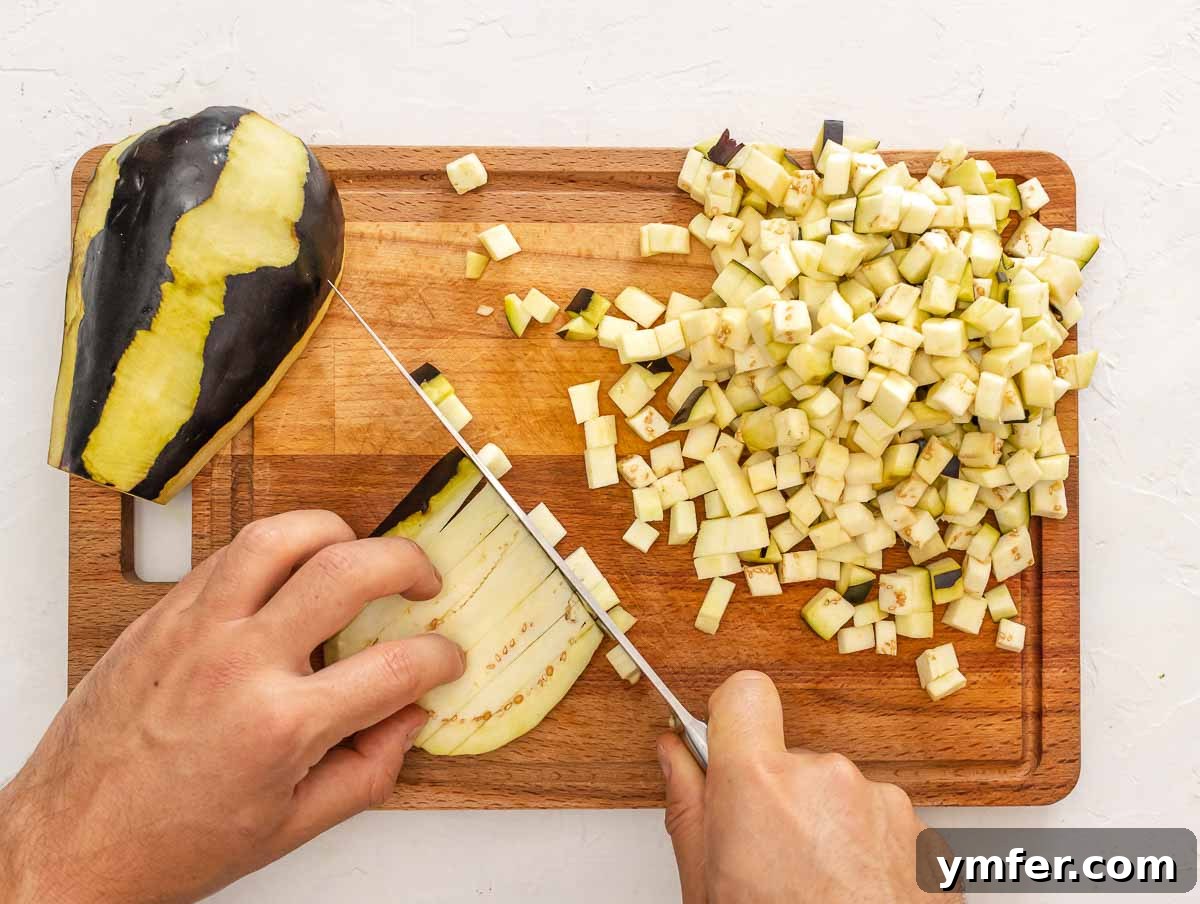 Velvet Aubergine Risotto 6 Chef dicing eggplant into 1/4 inch pieces on a cutting board.