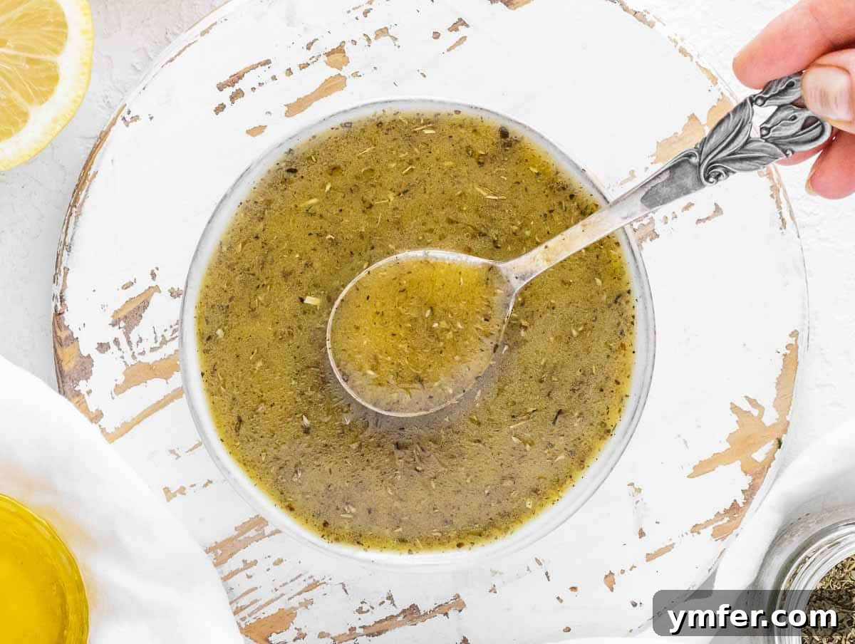 Homemade Italian dressing being shaken in a glass jar