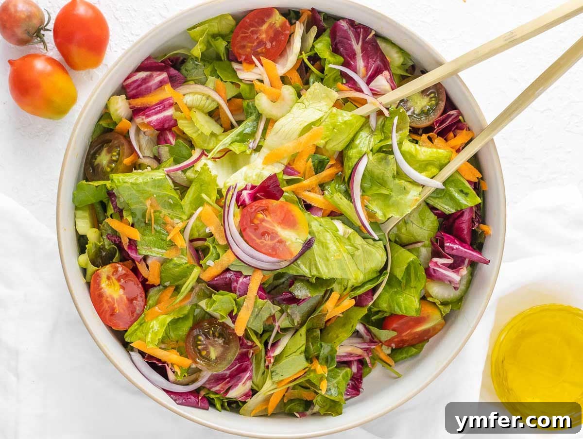 A smaller, simpler side salad in a bowl with basic greens and vinaigrette