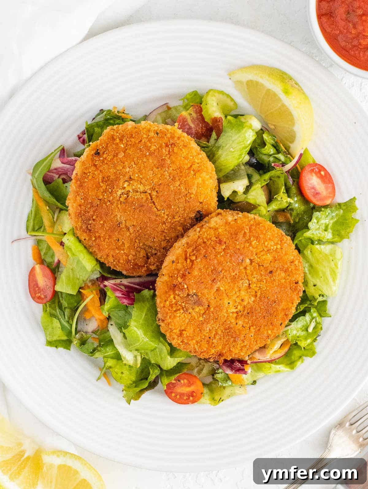 Arancini 2 Crispy risotto cakes served on a fresh side salad with a vibrant green backdrop
