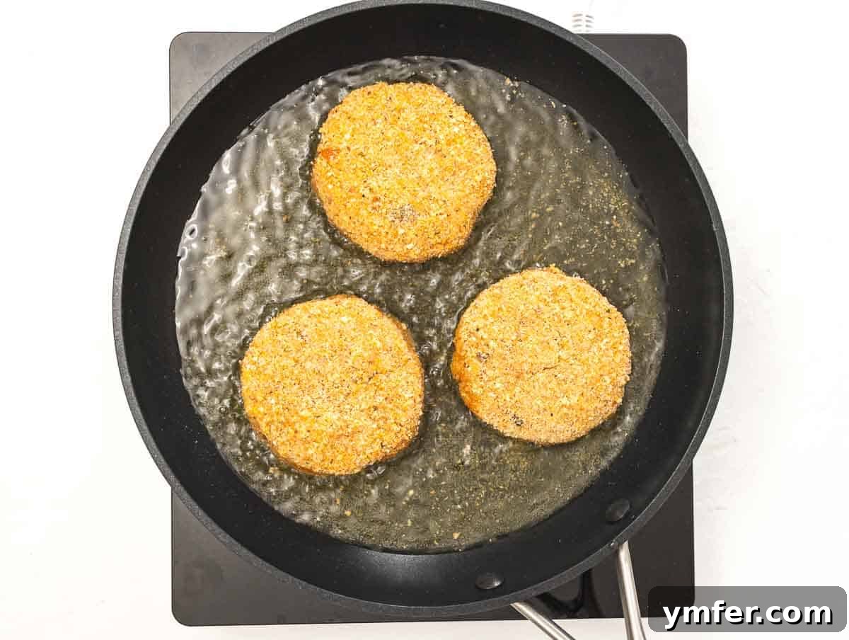 Arancini 9 Risotto cakes shallow frying in a large pan filled with hot oil.
